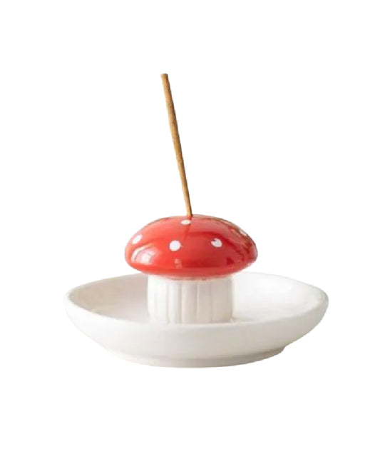 Mushroom-shaped incense holder with a red cap and white spots on a white background