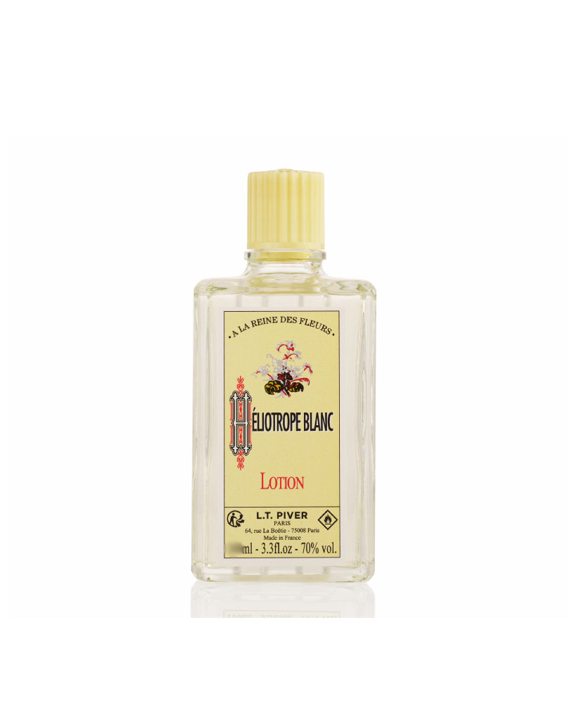 Bottle of Heliotrope Blanc lotion with a yellow label on a white background