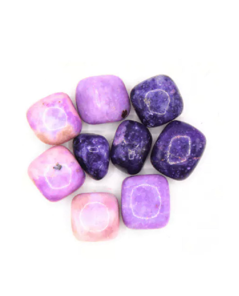 Purple and pink tumbled stones on a white background