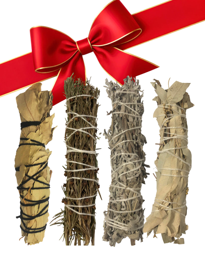 Four bundles of sage wrapped in different materials with a red ribbon on a white background